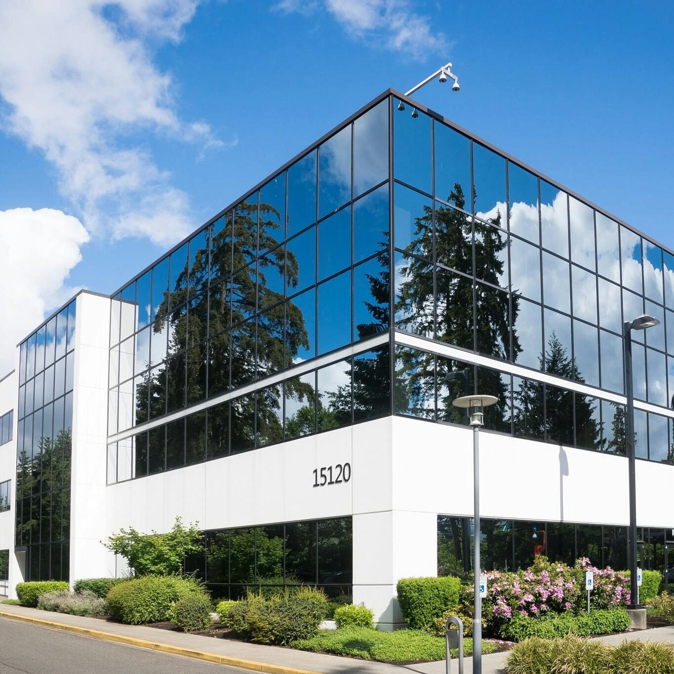 Contemporary office building in Redmond with reflective glass and lush greenery, captured on a sunny day.